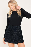 A woman modeling a navy blue tweed mini skort with subtle silver and white speckles | Flying Tomato