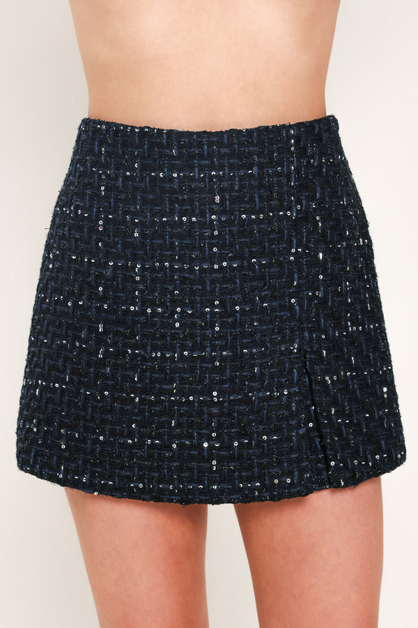 A woman modeling a navy blue tweed mini skort with subtle silver and white speckles | Flying Tomato