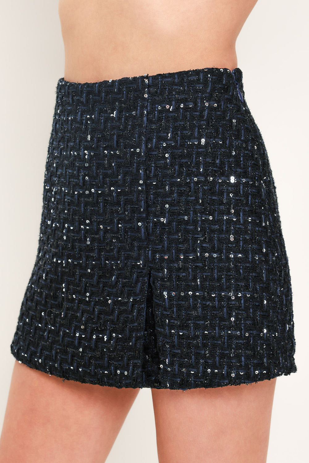 A woman modeling a navy blue tweed mini skort with subtle silver and white speckles | Flying Tomato