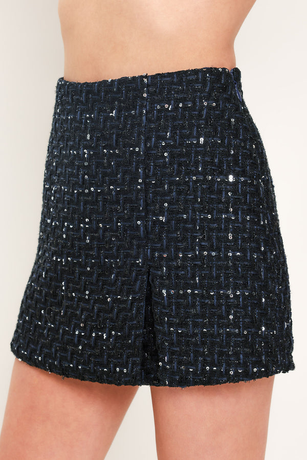 A woman modeling a navy blue tweed mini skort with subtle silver and white speckles | Flying Tomato