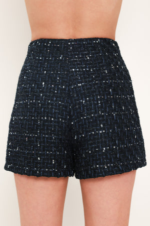A woman modeling a navy blue tweed mini skort with subtle silver and white speckles | Flying Tomato