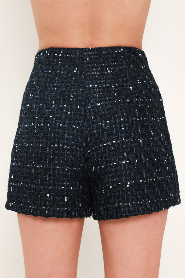 A woman modeling a navy blue tweed mini skort with subtle silver and white speckles | Flying Tomato