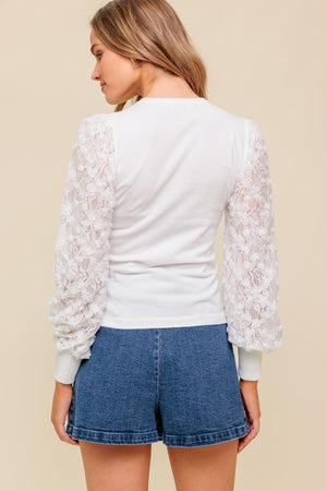 A sweater knit top featuring round neckline with contrasting sleeve