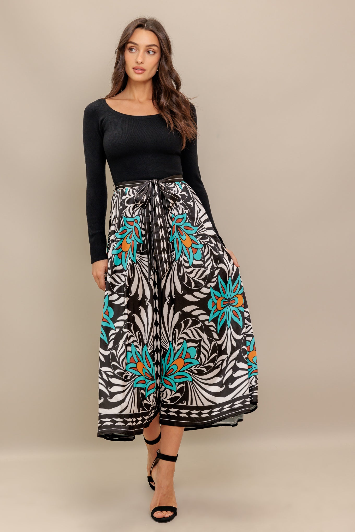 A midi dress featuring sweater top with long sleeve, self sash and printed woven skirt