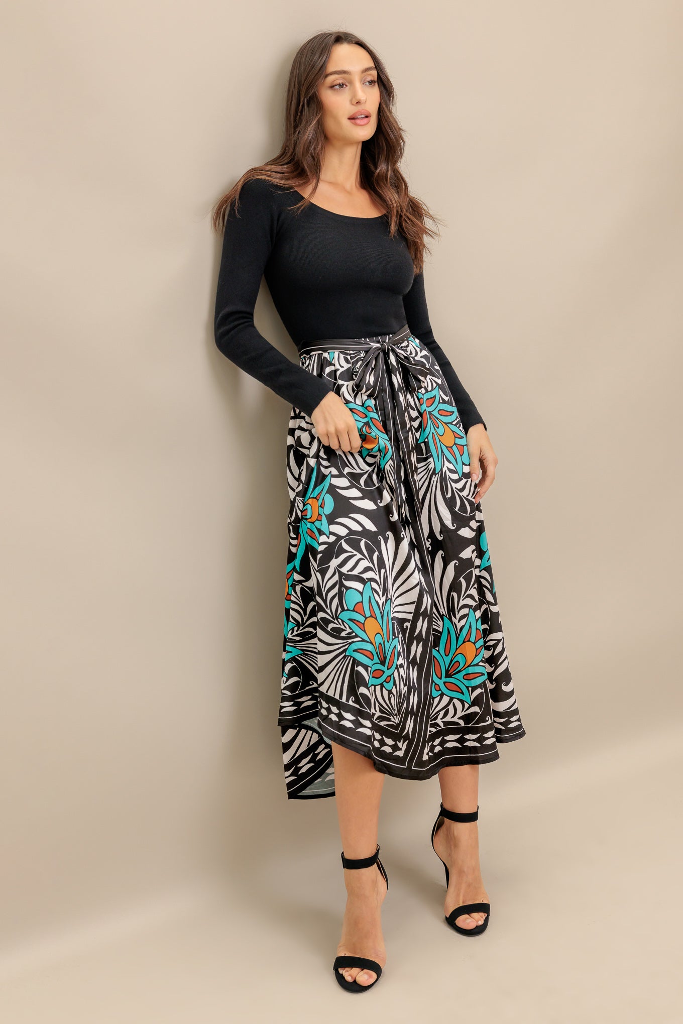 A midi dress featuring sweater top with long sleeve, self sash and printed woven skirt