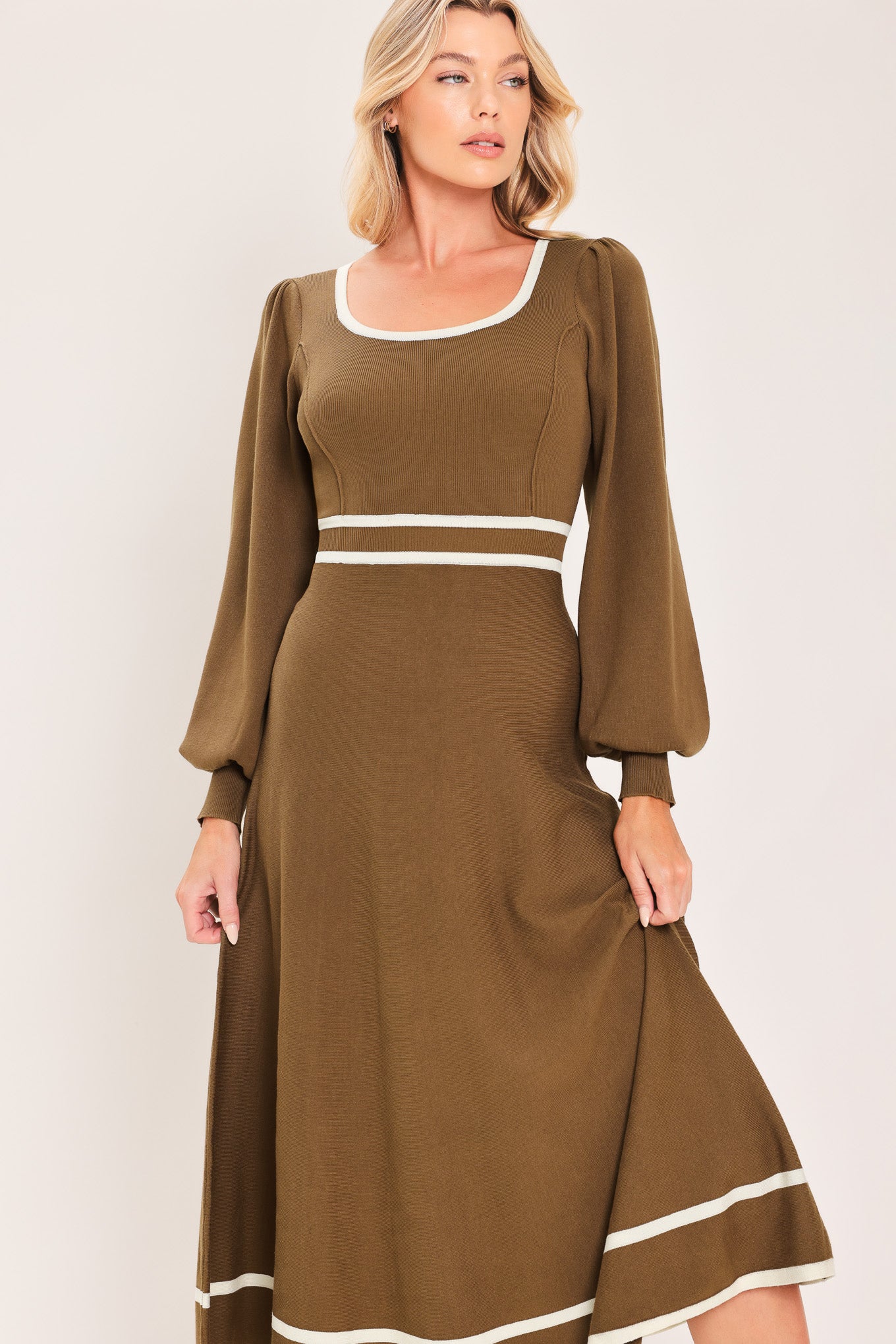 A woman modeling a brown midi dress with white trim details, including a square neckline, sleeve cuffs, a horizontal waist stripe, and a hemline | Flying tomato