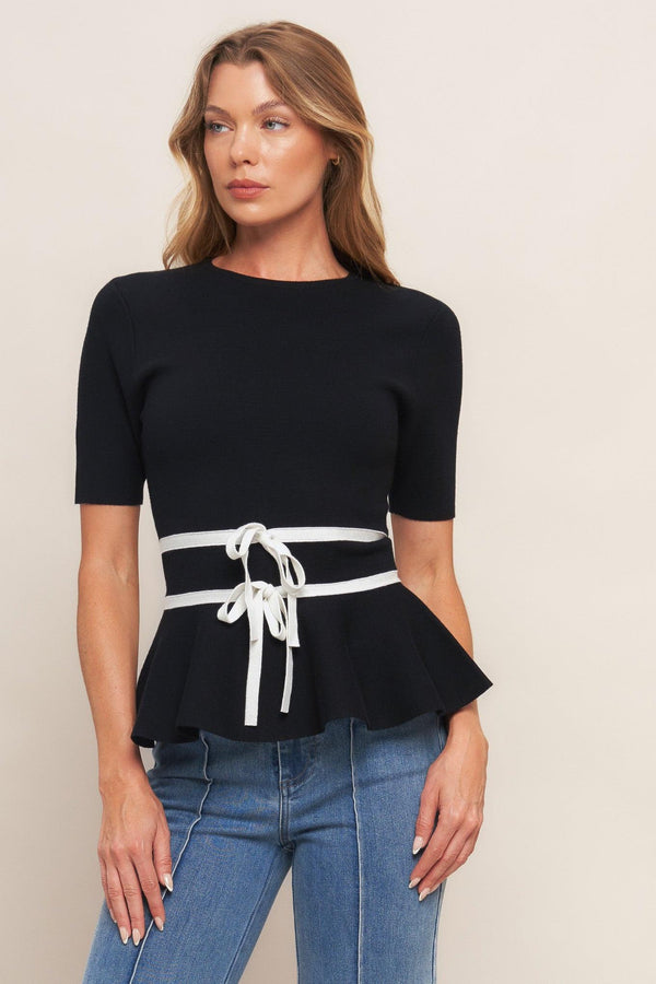A solid sweater knit top featuring round neckline, short sleeve, bow front, peplum and back zipper closure