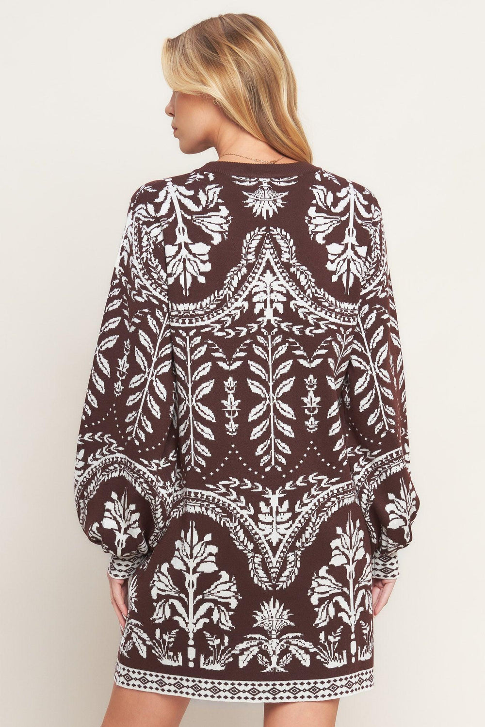 A sweater knit mini dress featuring crew neckline and long blouson sleeve
