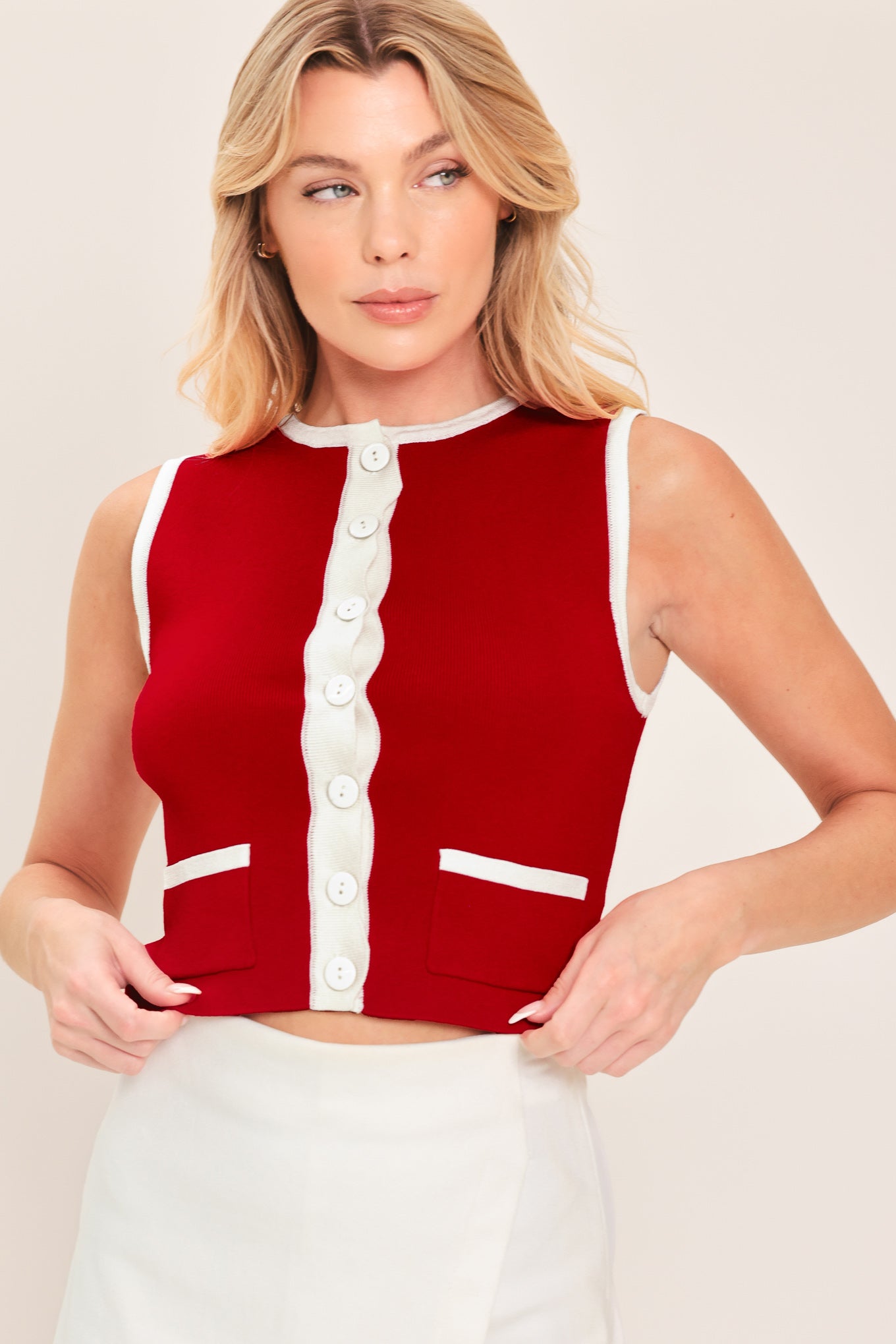 Woman wearing a sleeveless red and white color blocked sweater knit top top with white buttons | Flying Tomato