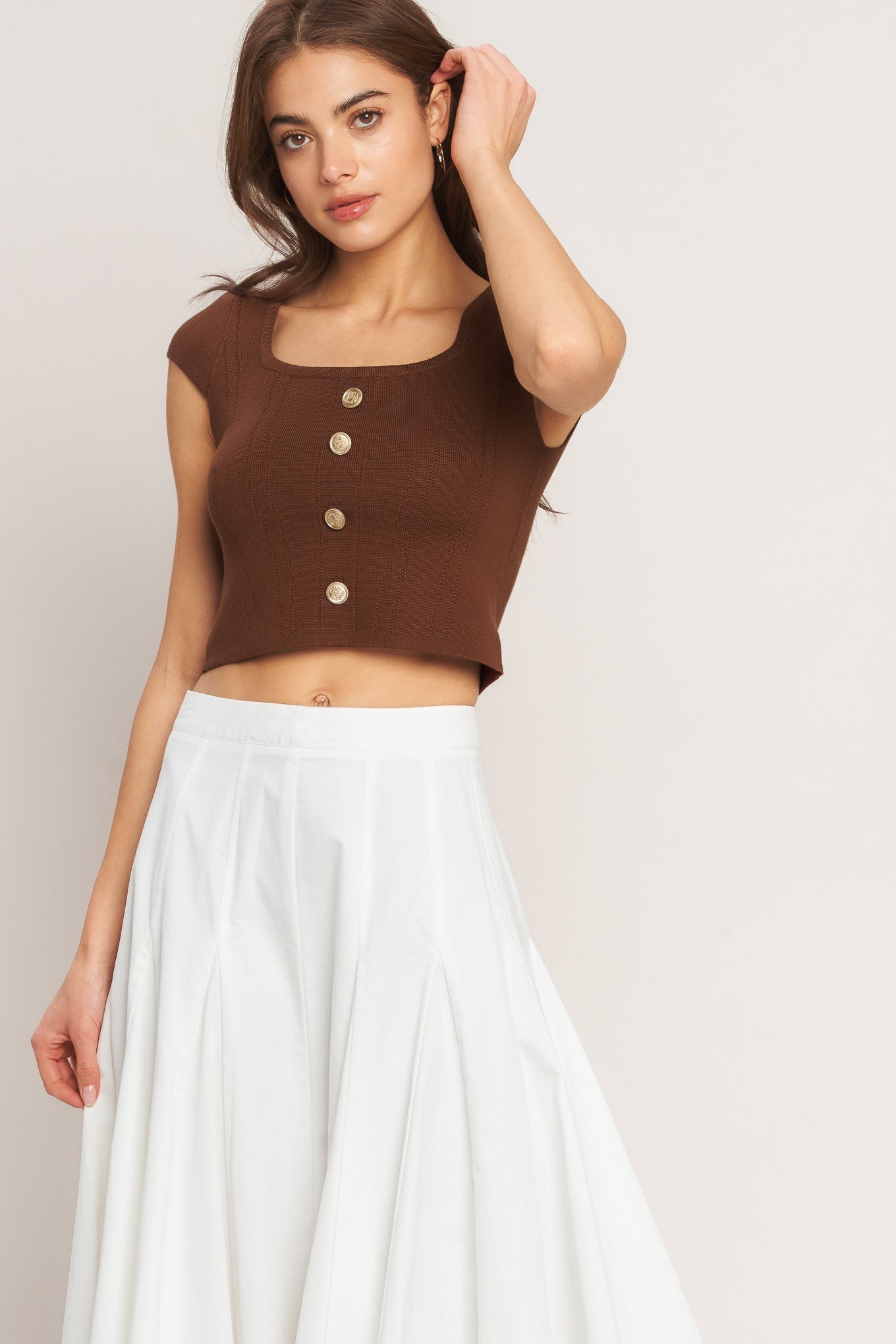 A brown sweater knit top featuring square neckline, cap sleeve and front button detail