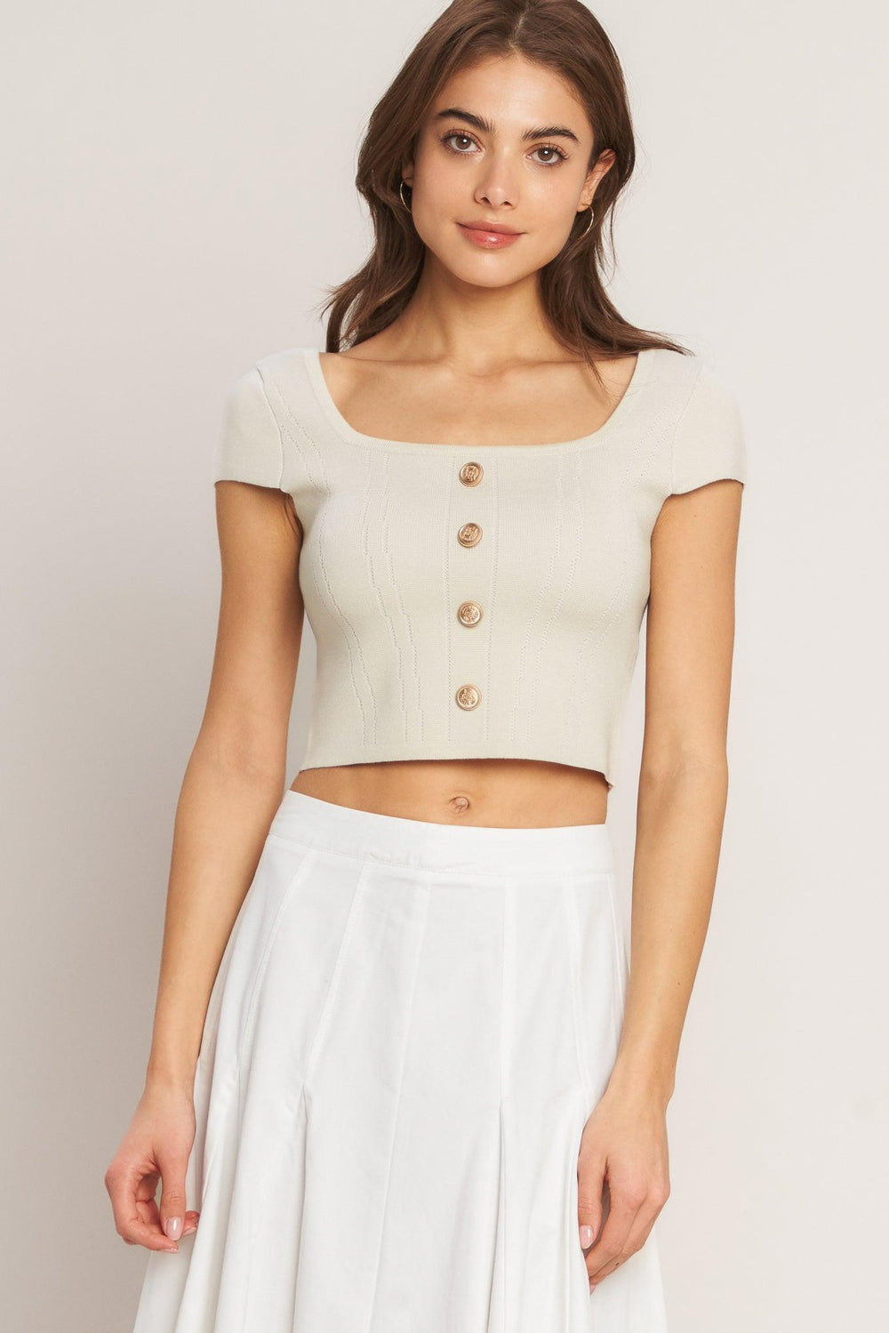 A sweater knit top featuring square neckline, cap sleeve and front button detail