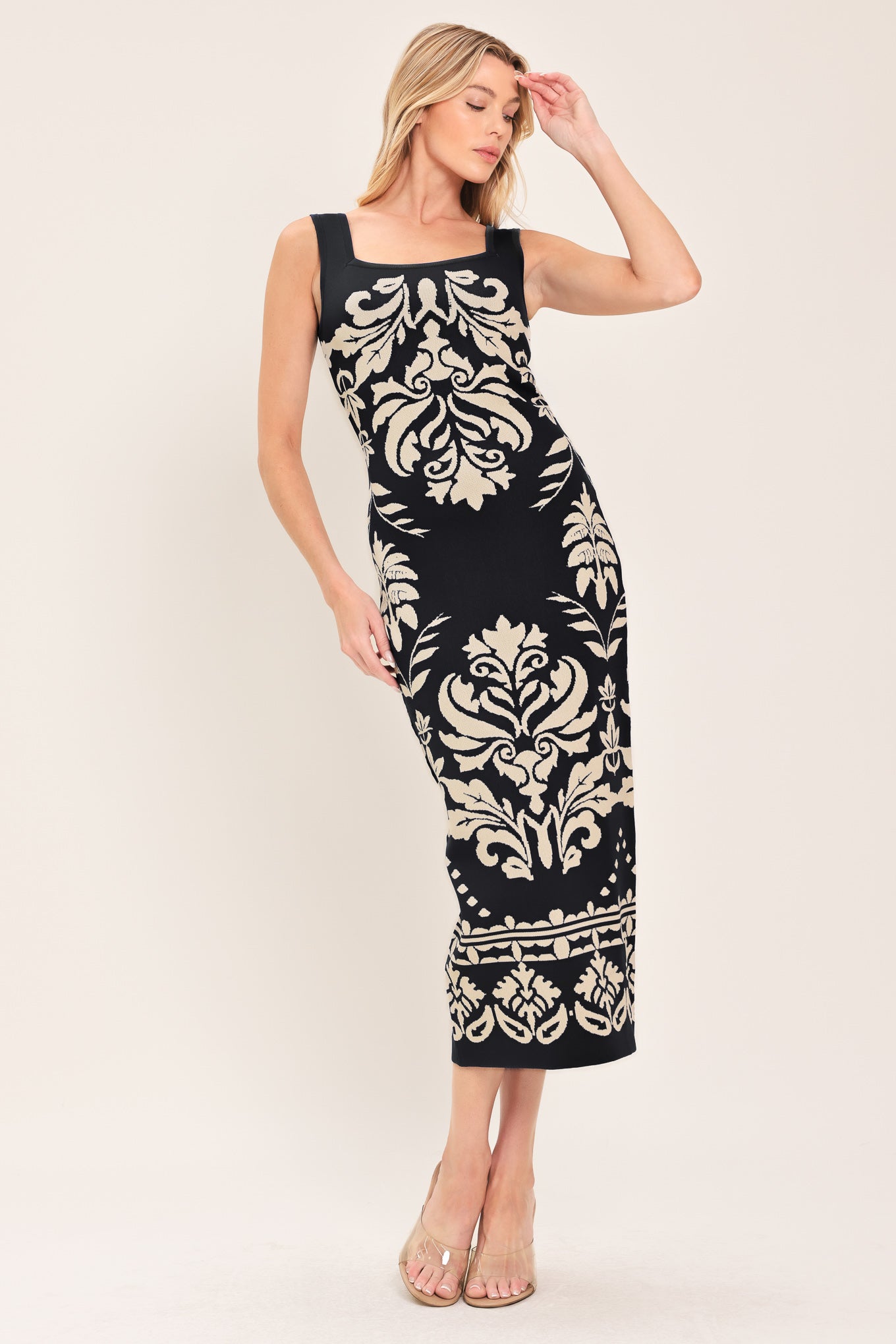 Woman wearing a black and beige sleeveless floral jacquard sweater knit midi dress with square neckline | Flying Tomato