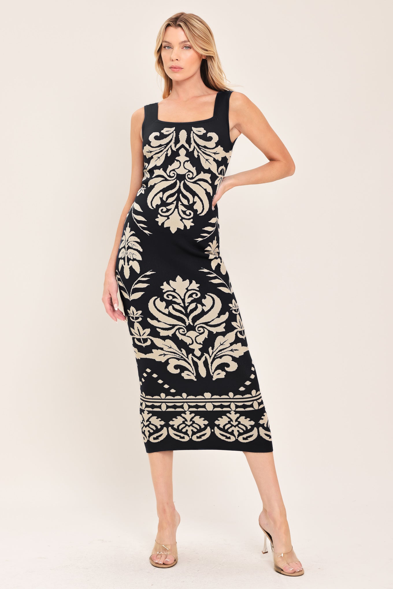 Woman wearing a black and beige sleeveless floral jacquard sweater knit midi dress with square neckline | Flying Tomato