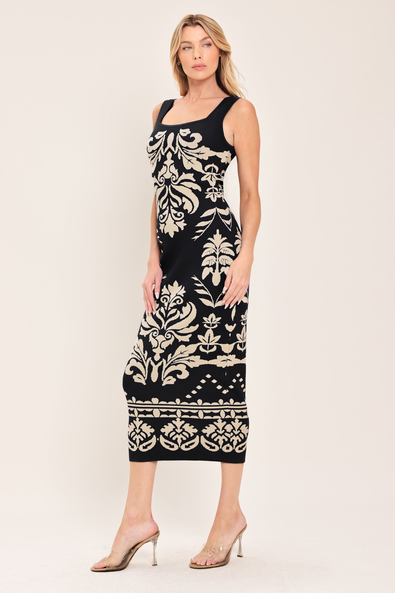 Woman wearing a black and beige sleeveless floral jacquard sweater knit midi dress with square neckline | Flying Tomato