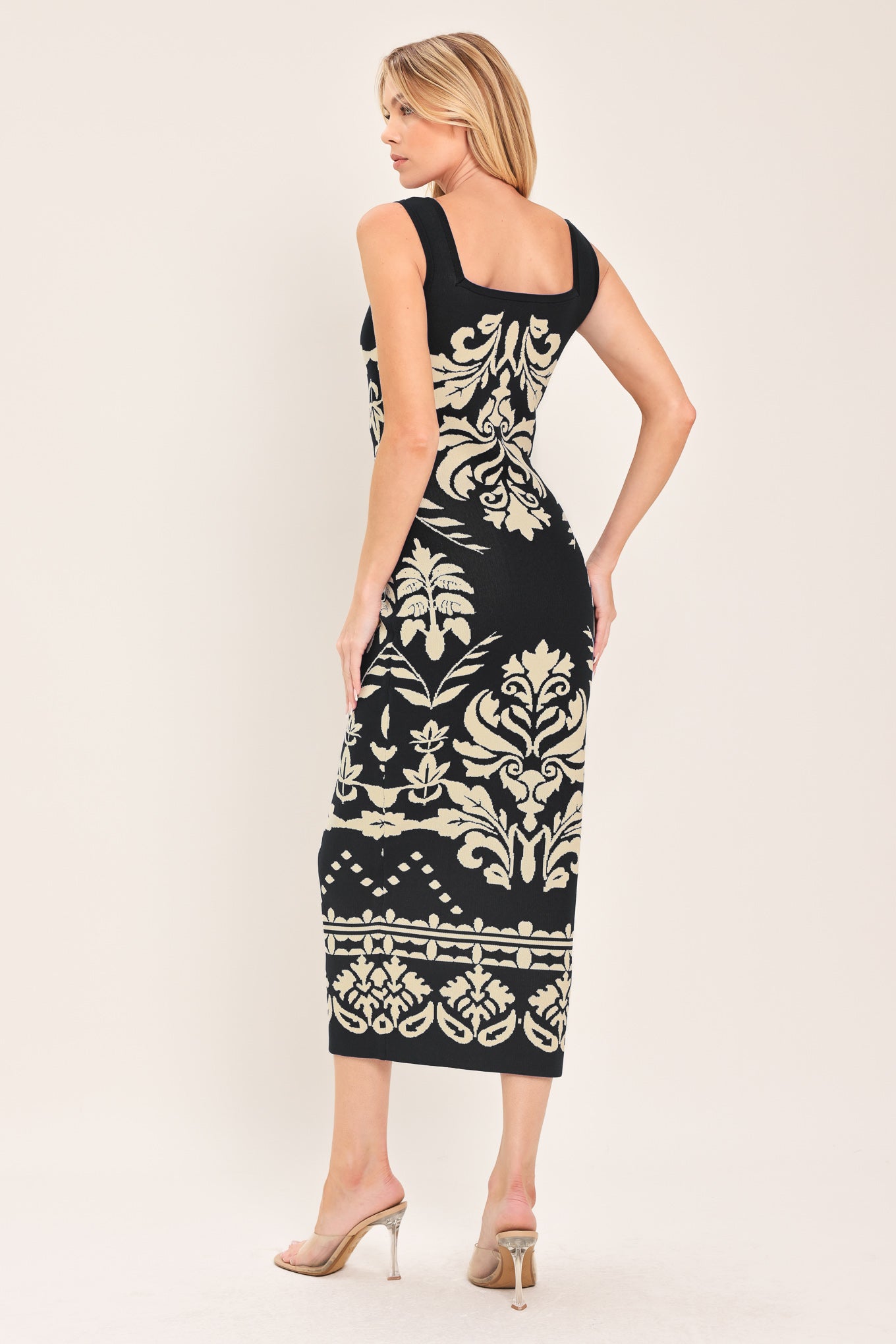 Woman wearing a black and beige sleeveless floral jacquard sweater knit midi dress with square neckline | Flying Tomato