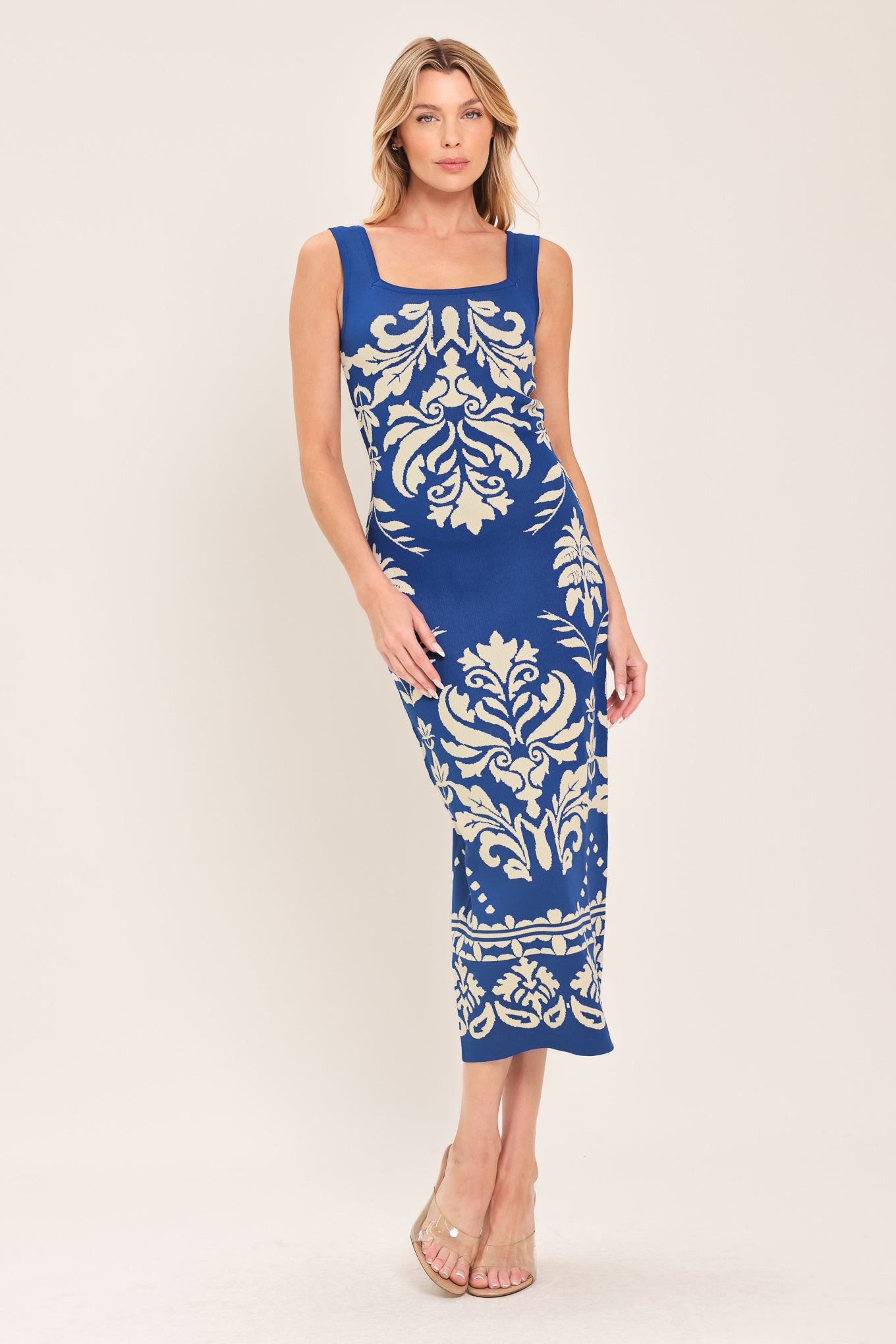 Woman wearing a blue and beige sleeveless floral jacquard sweater knit midi dress with square neckline | Flying Tomato