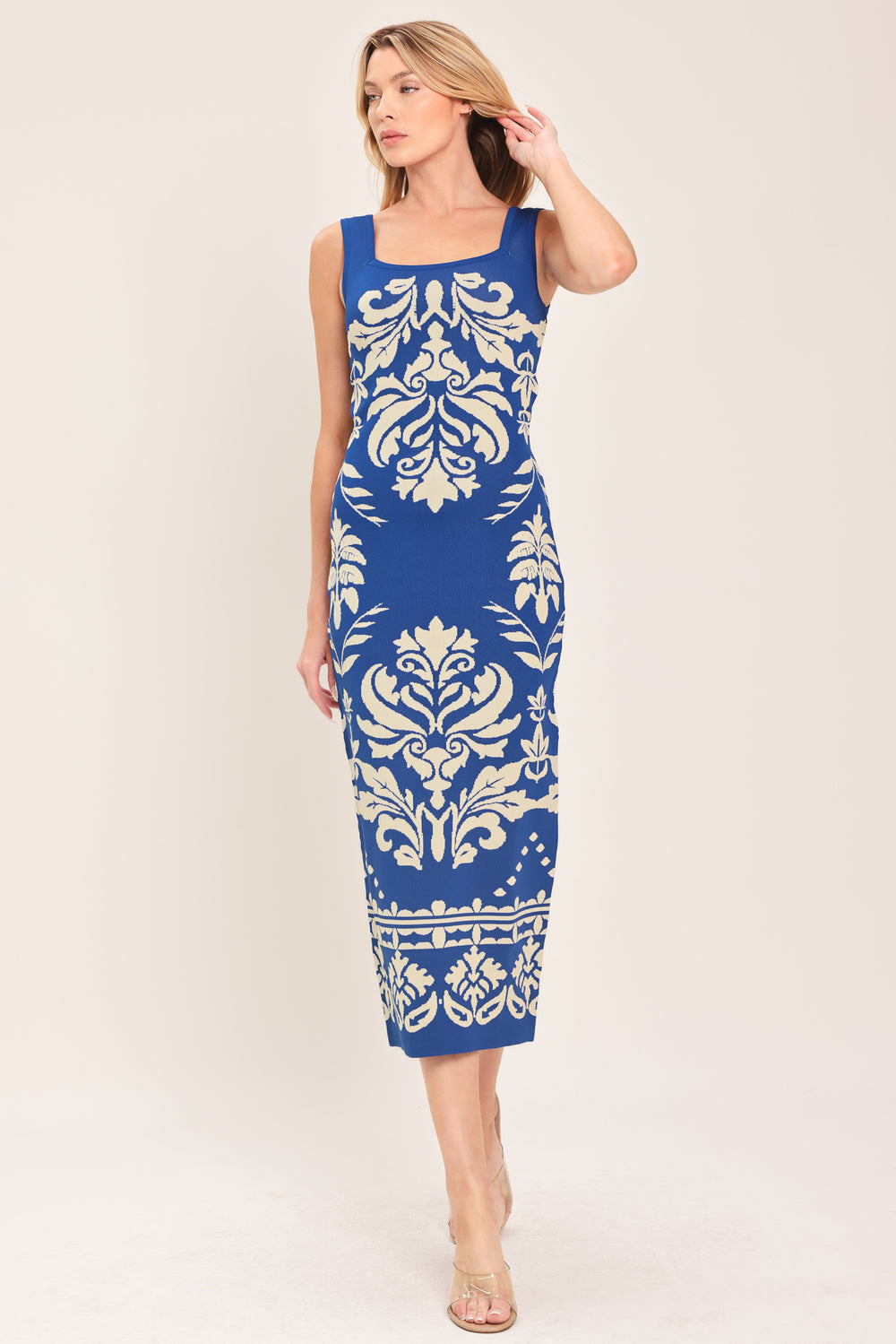 Woman wearing a blue and beige sleeveless floral jacquard sweater knit midi dress with square neckline | Flying Tomato