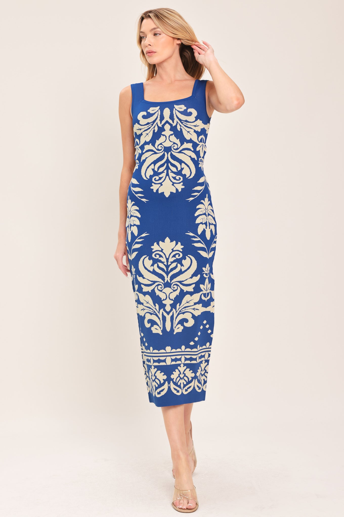 Woman wearing a blue and beige sleeveless floral jacquard sweater knit midi dress with square neckline | Flying Tomato