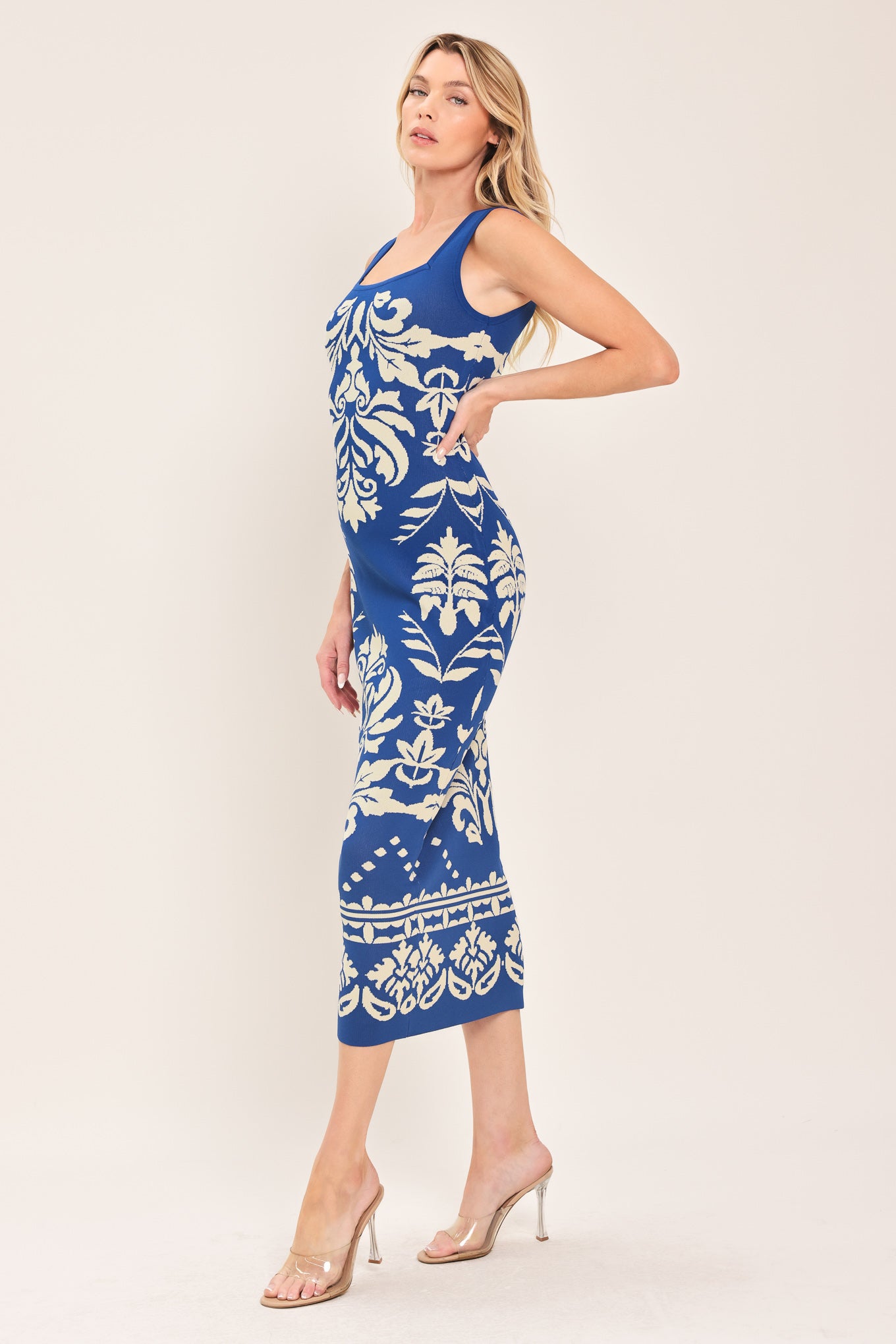 Woman wearing a blue and beige sleeveless floral jacquard sweater knit midi dress with square neckline | Flying Tomato