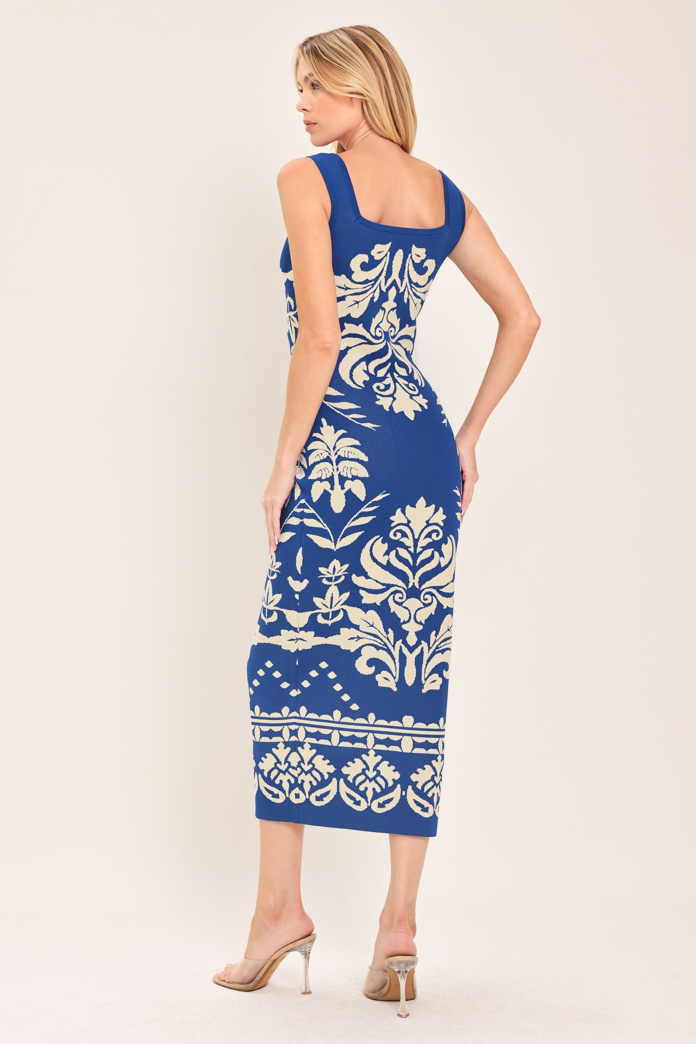 Woman wearing a blue and beige sleeveless floral jacquard sweater knit midi dress with square neckline | Flying Tomato