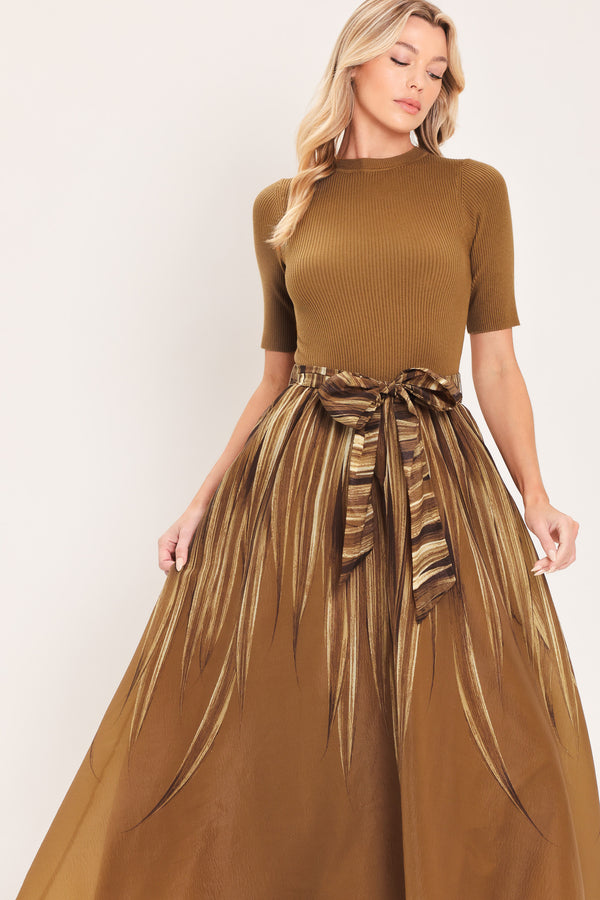 A woman modeling a brown midi dress with a short-sleeve mock neck top, pleated skirt, and a matching fabric tie belt | Flying Tomato