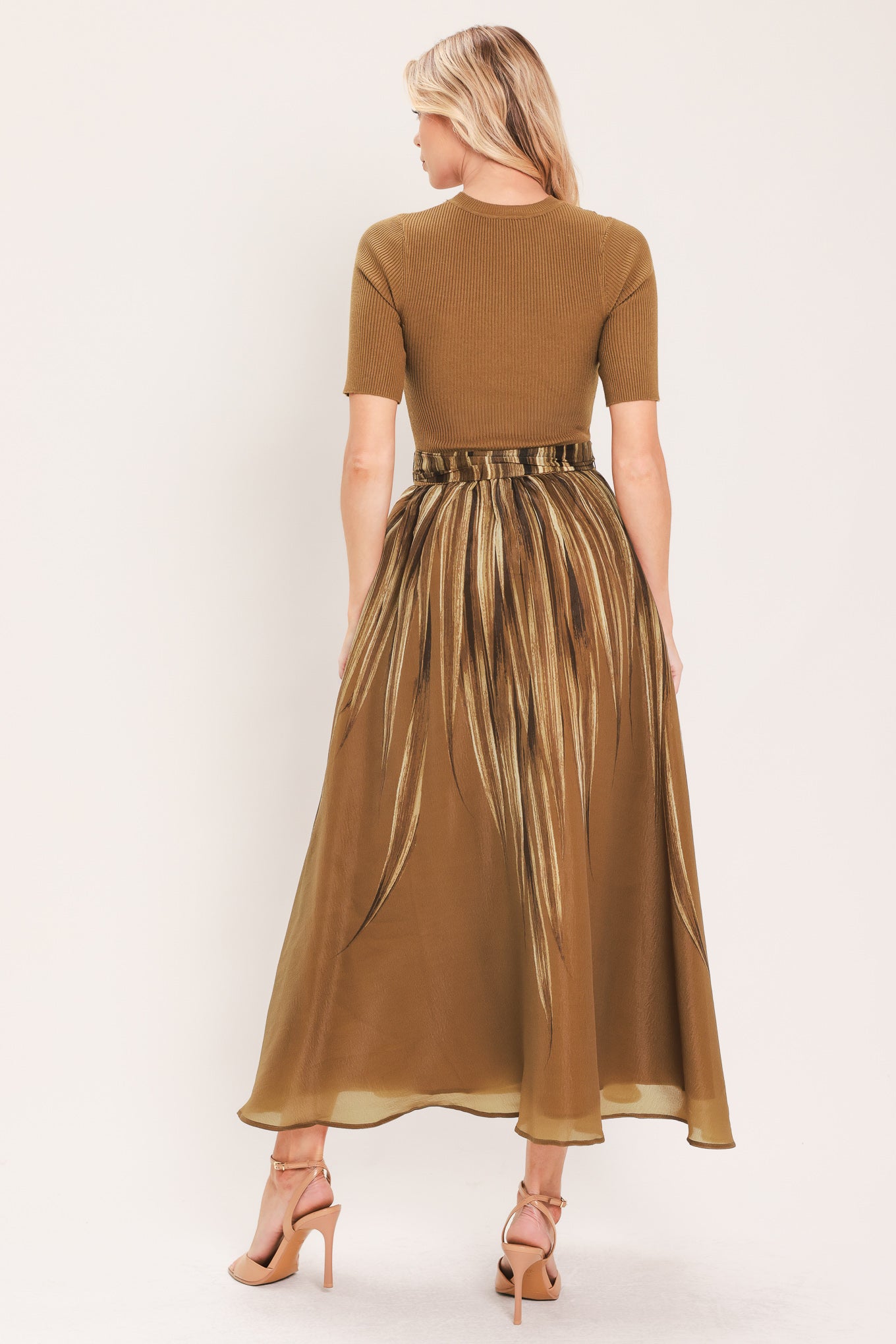 A woman modeling a brown midi dress with a short-sleeve mock neck top, pleated skirt, and a matching fabric tie belt | Flying Tomato