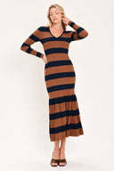 A woman modeling a long-sleeve ribbed knit midi dress with horizontal brown and navy and rust stripes, featuring a V-neckline and a flared mermaid-style hem | Flying Tomato