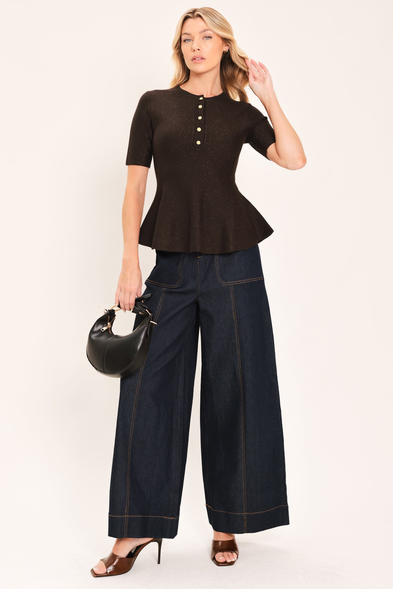A woman modeling a short-sleeve knit top in dark brown with a buttoned henley neckline and a peplum hem | Flying Tomato