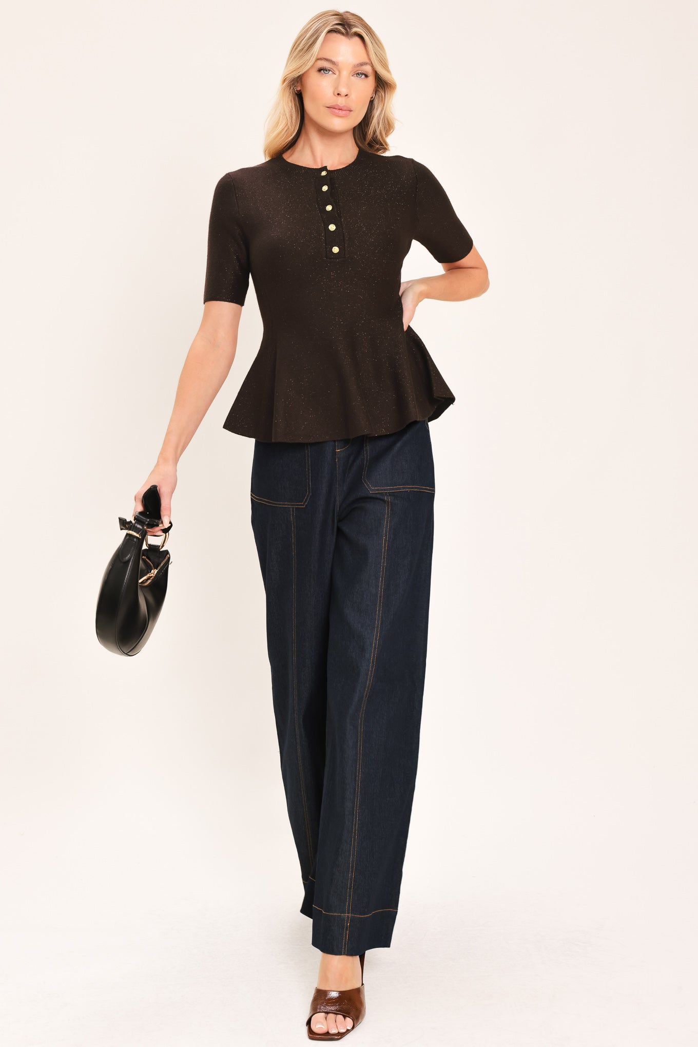 A woman modeling a short-sleeve knit top in dark brown with a buttoned henley neckline and a peplum hem | Flying Tomato