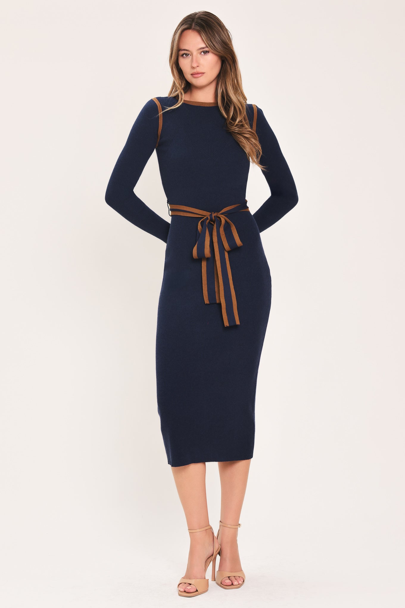 A woman modeling a navy blue long-sleeve midi dress with brown trim details on the shoulders and a matching brown tie belt at the waist | Flying Tomato