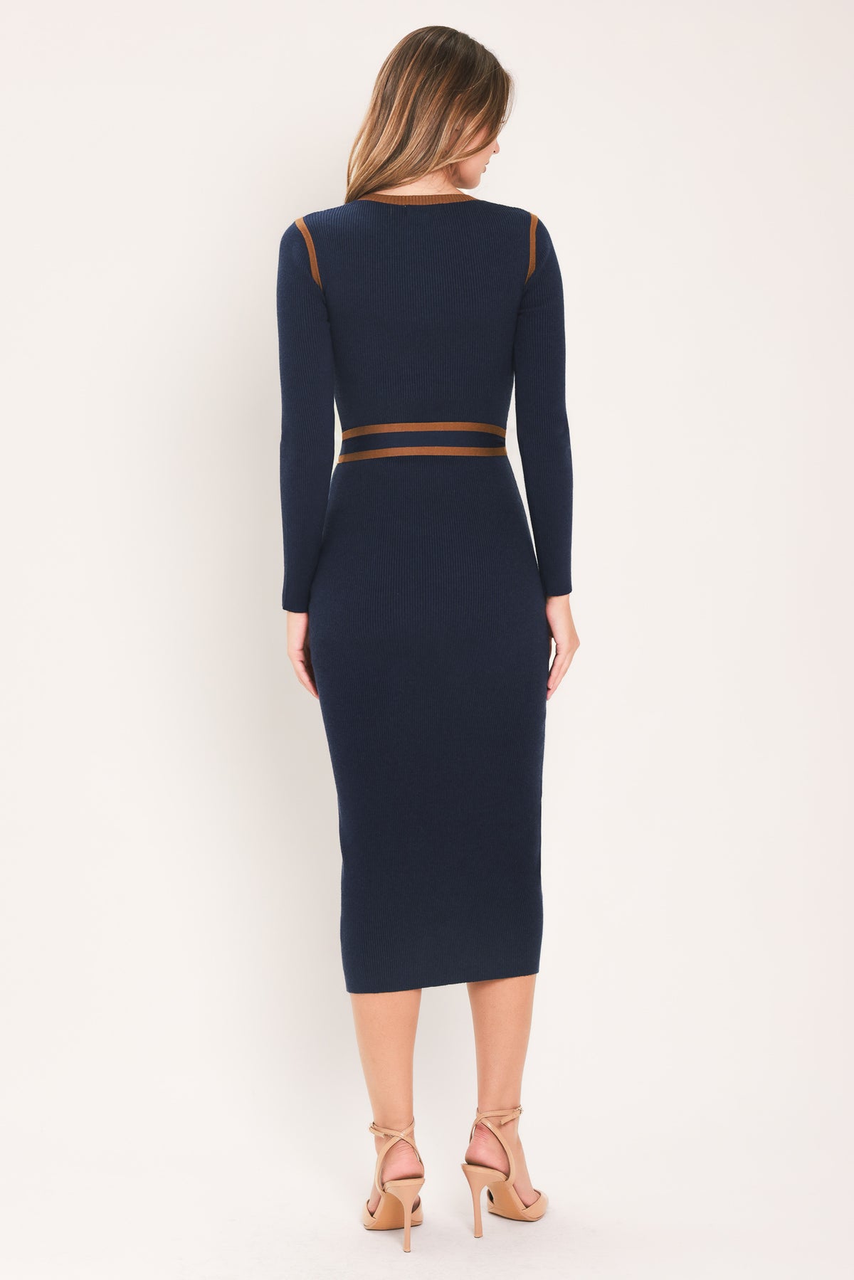 A woman modeling a navy blue long-sleeve midi dress with brown trim details on the shoulders and a matching brown tie belt at the waist | Flying Tomato