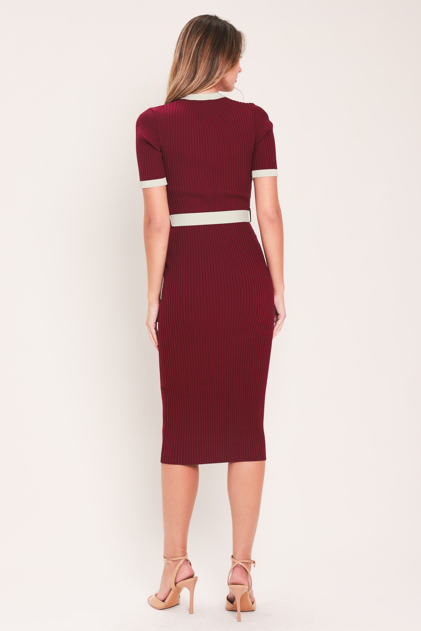 A woman models a short-sleeve ribbed knit midi dress in deep burgundy with cream trim details, including the collar, front placket, and matching tie belt | Flying Tomato