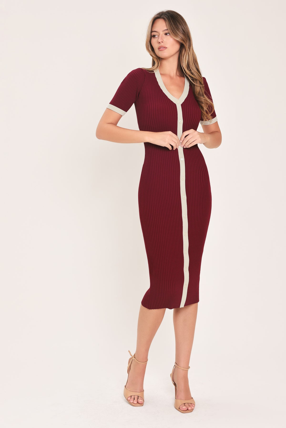 A woman models a short-sleeve ribbed knit midi dress in deep burgundy with cream trim details, including the collar, front placket, and matching tie belt | Flying Tomato