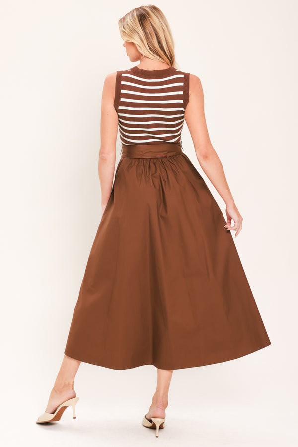A woman wearing a sleeveless midi dress with brown and white striped top and solid brown skirt featuring a matching tie belt | Flying Tomato