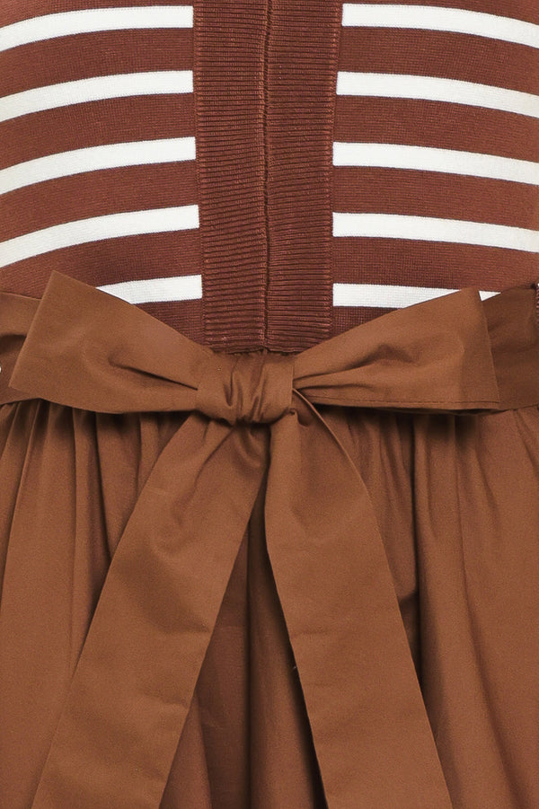 A woman wearing a sleeveless midi dress with brown and white striped top and solid brown skirt featuring a matching tie belt | Flying Tomato