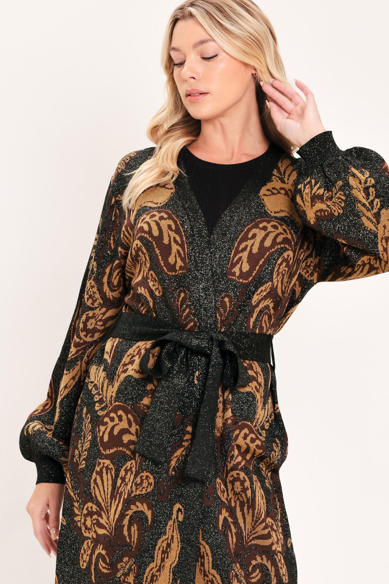 A woman modeling a long black cardigan with a brown baroque-style floral pattern | Flying Tomato
