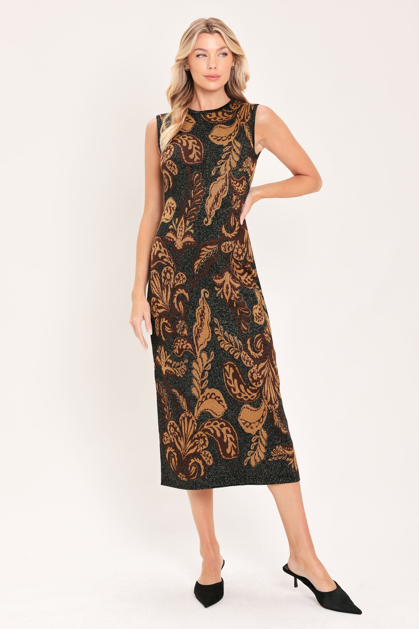 A woman modeling a sleeveless midi dress with a black base and an intricate gold metallic botanical and scroll pattern | Flying Tomato