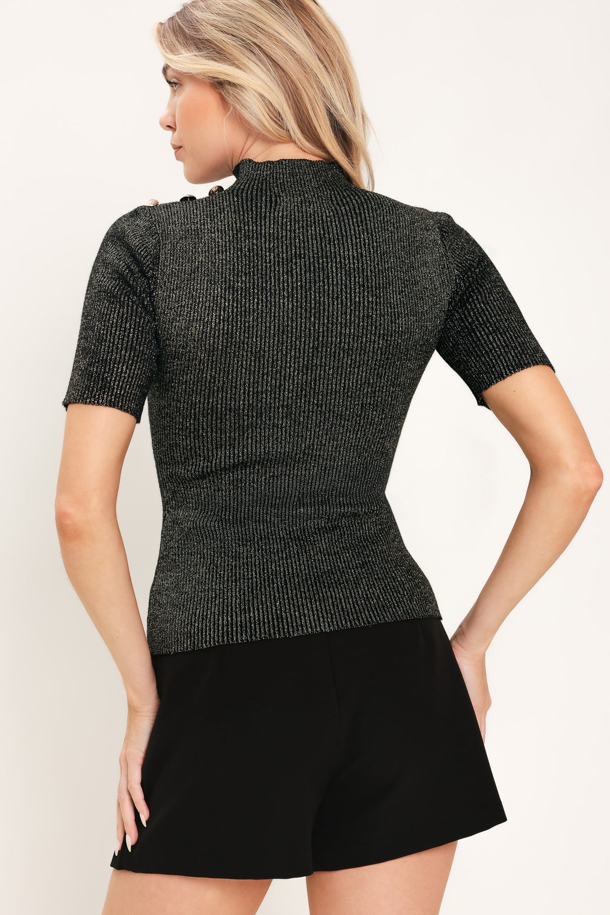 A woman modeling a short-sleeve ribbed knit mock neck black metallic top | Flying Tomato