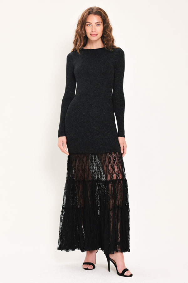 Woman wearing a long sleeve black sweater knit maxi dress but the sweater portion stops at the thighs and the bottom of the dress is tiered lace | Flying Tomato
