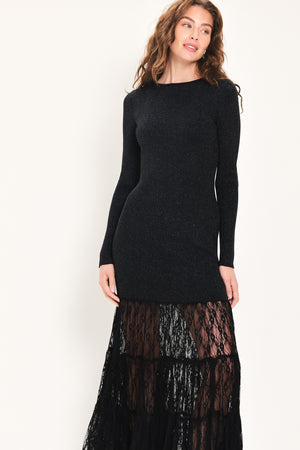Woman wearing a long sleeve black sweater knit maxi dress but the sweater portion stops at the thighs and the bottom of the dress is tiered lace | Flying Tomato
