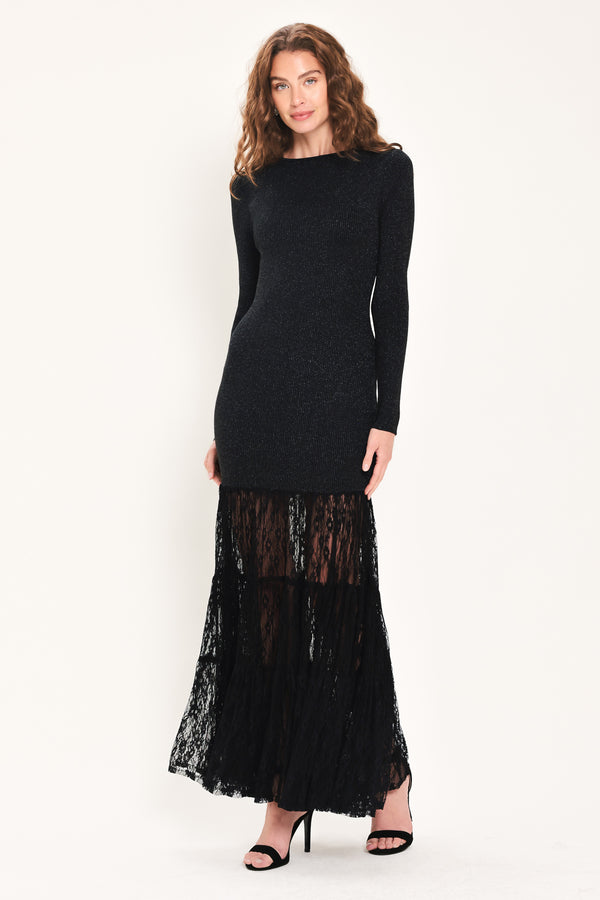 Woman wearing a long sleeve black sweater knit maxi dress but the sweater portion stops at the thighs and the bottom of the dress is tiered lace | Flying Tomato