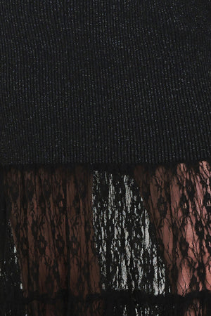 Woman wearing a long sleeve black sweater knit maxi dress but the sweater portion stops at the thighs and the bottom of the dress is tiered lace | Flying Tomato