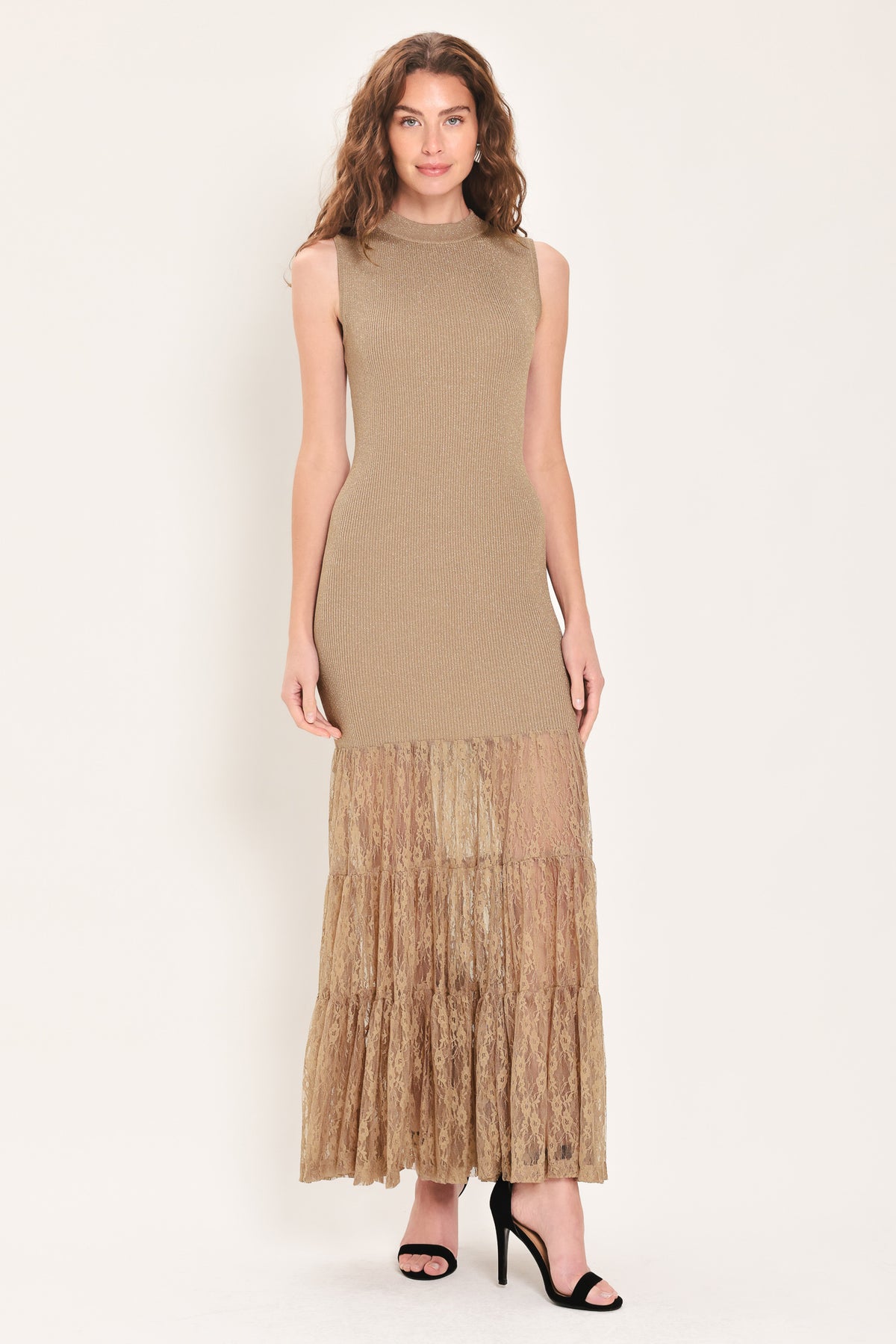 Woman wearing a sleeveless mock neck beige/gold metallic maxi dress with lace tiered skirt starting at the thighs | Flying Tomato