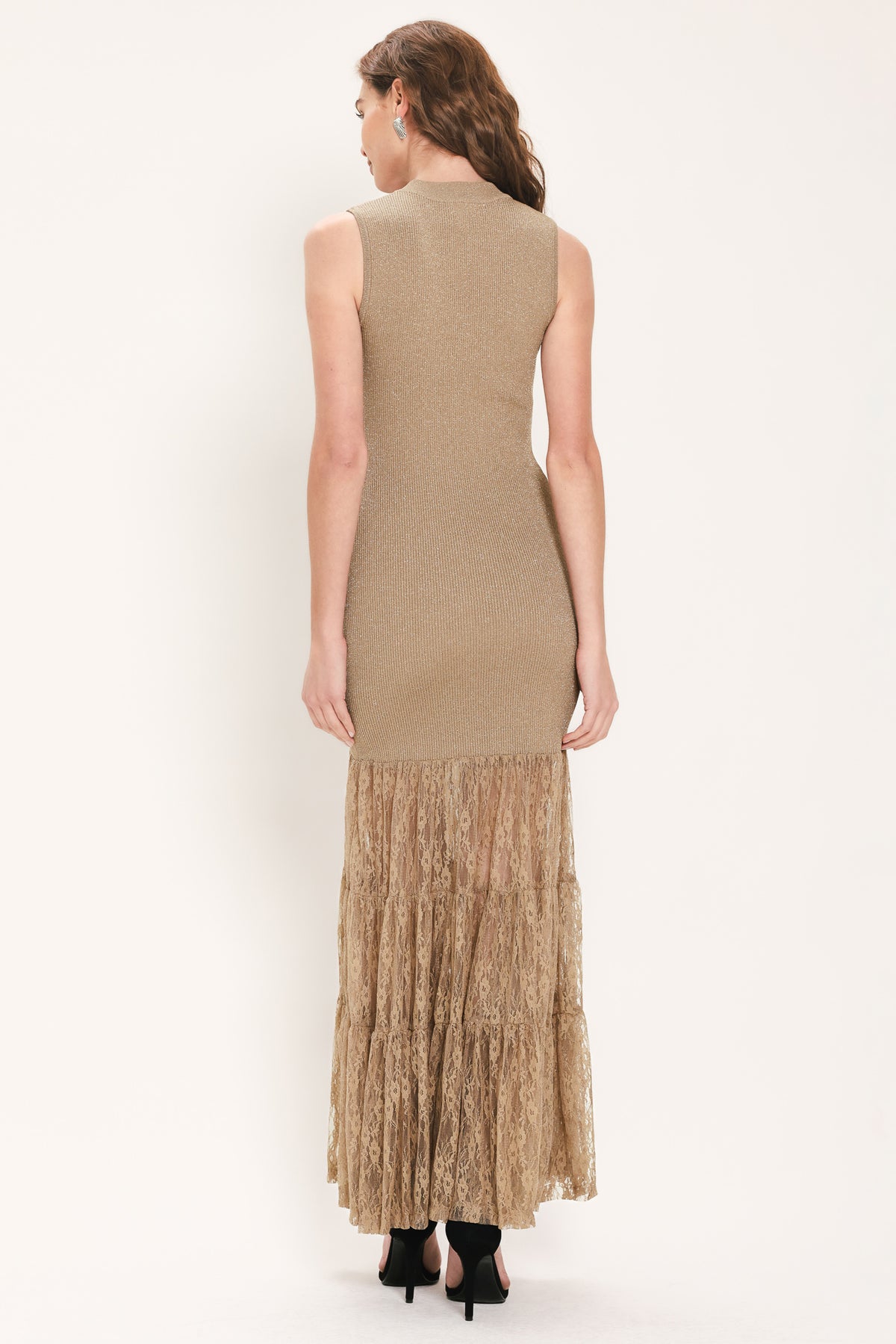 Woman wearing a sleeveless mock neck beige/gold metallic maxi dress with lace tiered skirt starting at the thighs | Flying Tomato