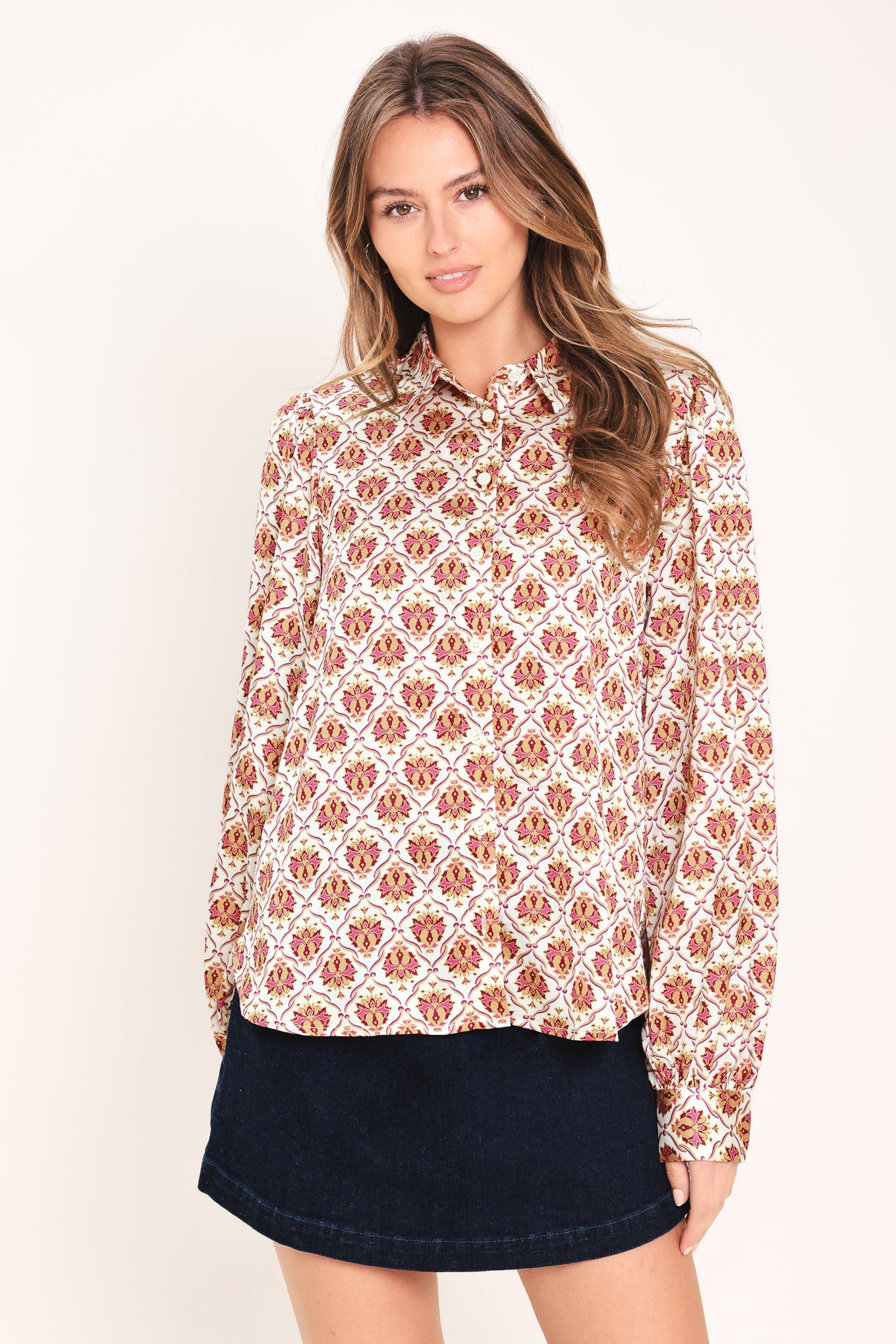 Woman wearing a burgundy long sleeve printed woven top featuring collar and button down | Flying Tomato