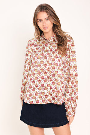 Woman wearing a burgundy long sleeve printed woven top featuring collar and button down | Flying Tomato