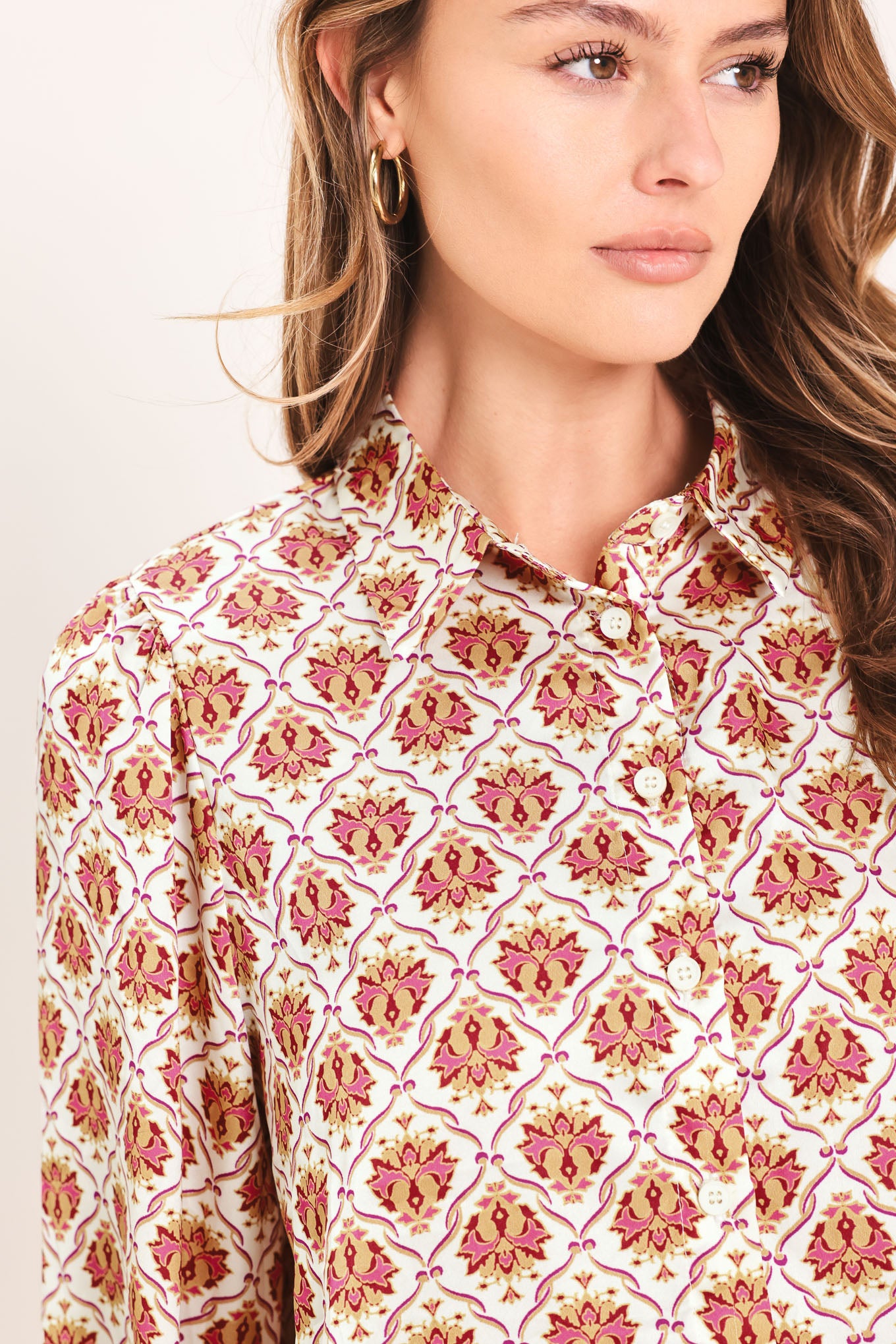 Woman wearing a burgundy long sleeve printed woven top featuring collar and button down | Flying Tomato