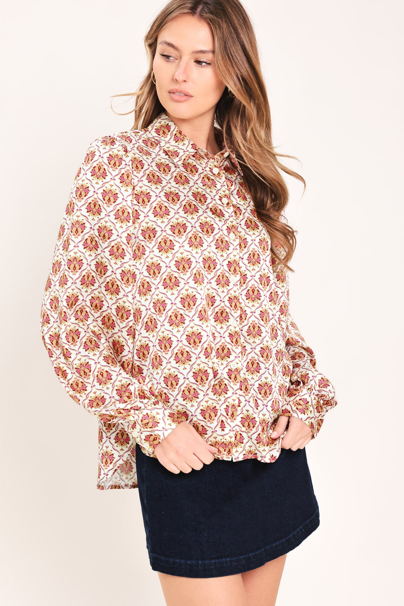 Woman wearing a burgundy long sleeve printed woven top featuring collar and button down | Flying Tomato