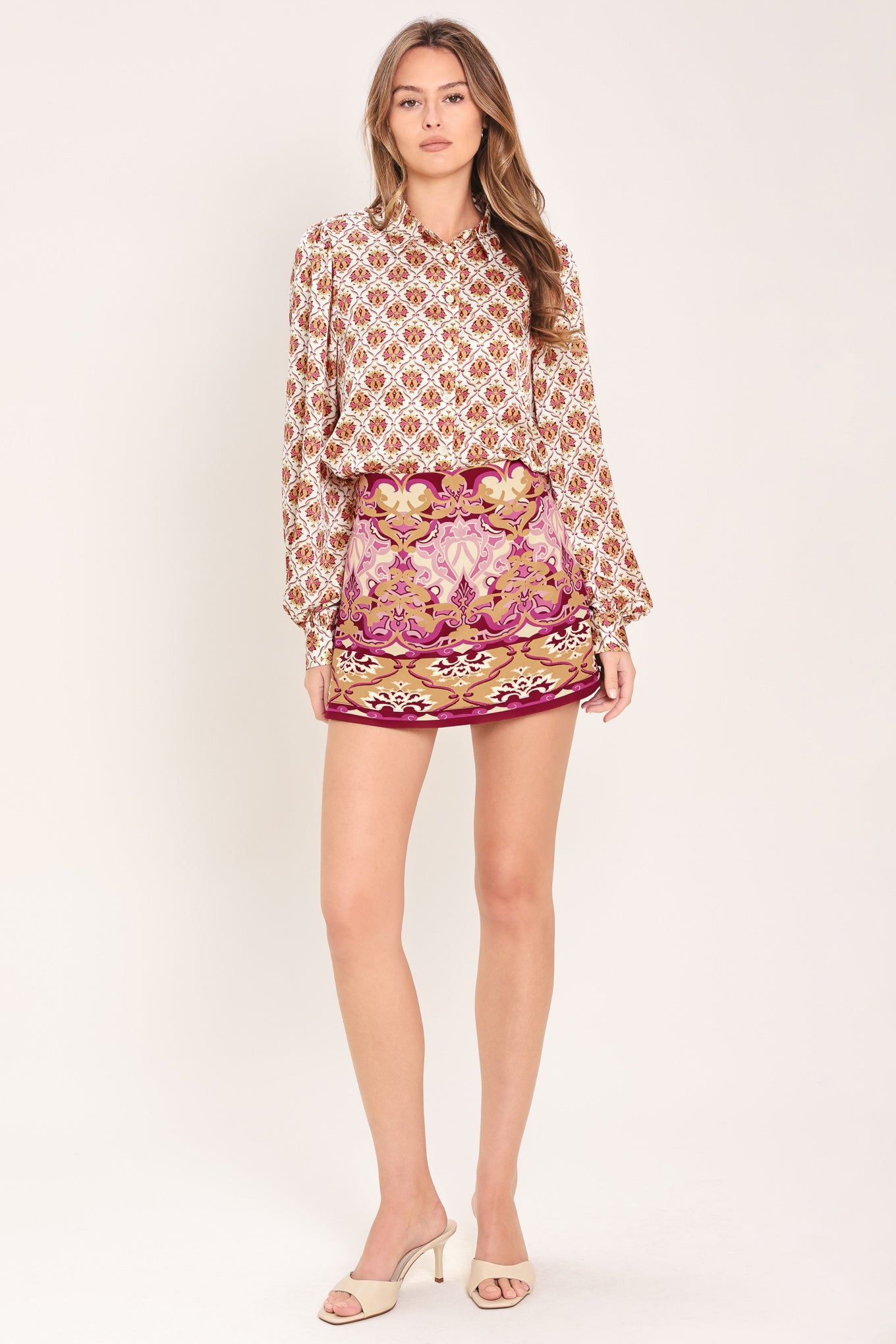 Woman wearing a burgundy long sleeve printed woven top featuring collar and button down | Flying Tomato