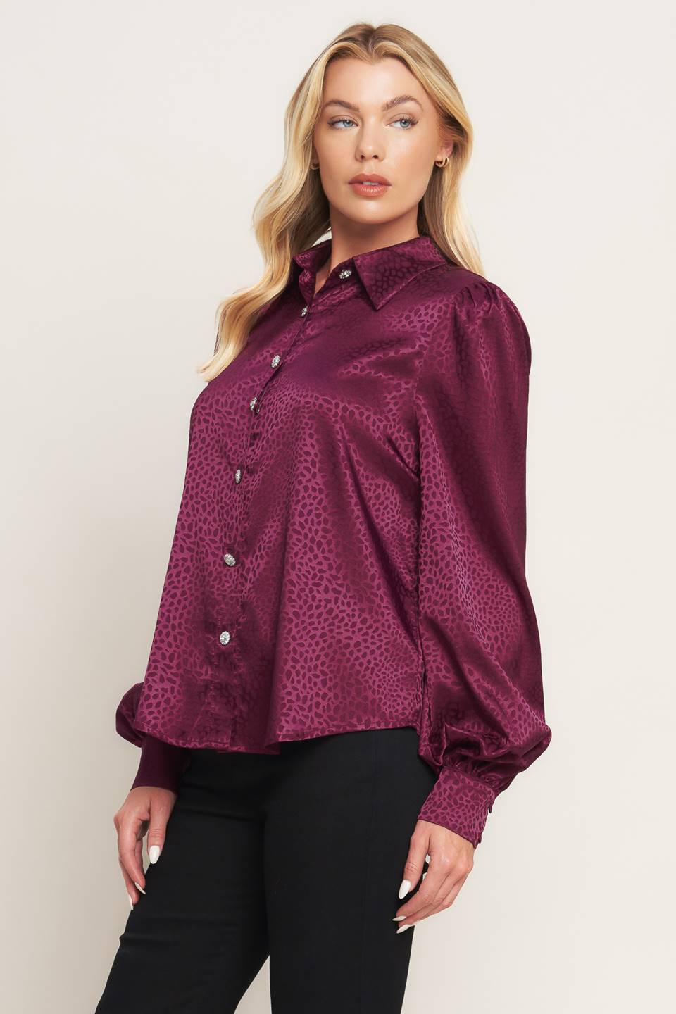 A solid woven top featuring shirt collar, jewel button down, long puff sleeve and cuff